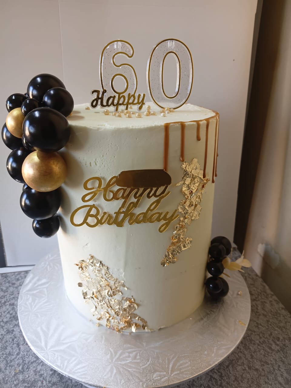 White black and gold 60th birthday cake with balloon cluster in Lichtenburg by Bridge Angels Treats